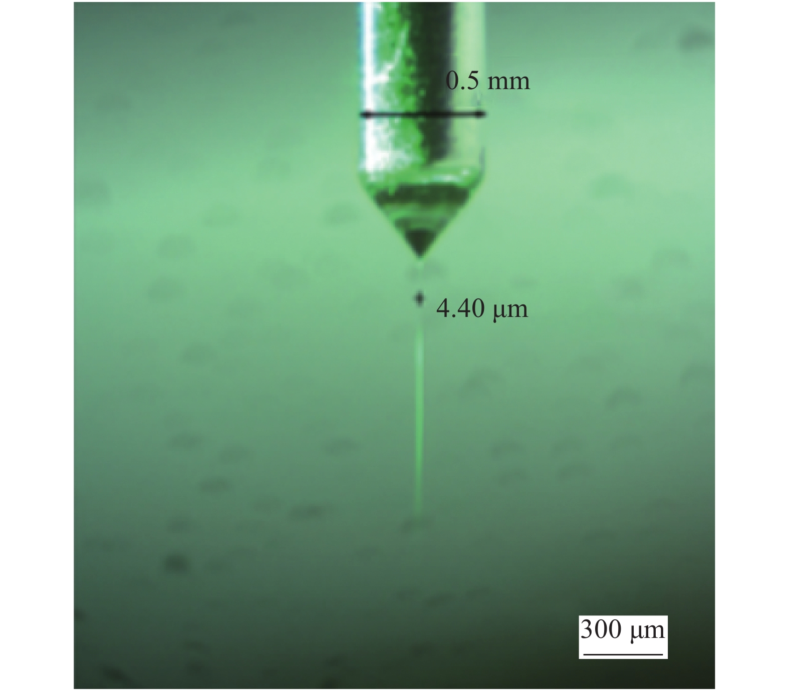 Picture of a nozzle with an internal diameter of 500 μm producing a jet with the diameter of 4.4 μm (Scale bar is 300 μm)