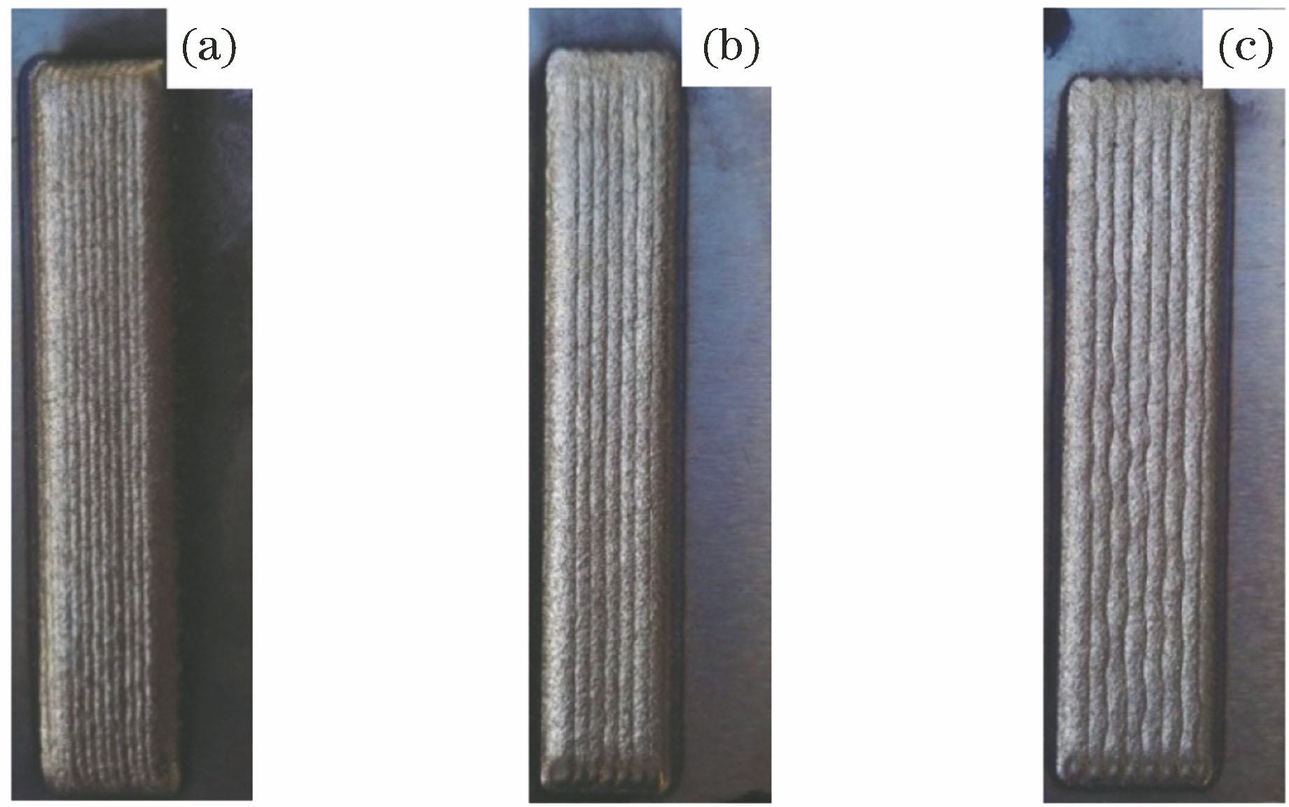 Macroscopic morphology of cladding layers with different overlap rates under ultrasonic vibration. (a) 66%; (b) 50%; (c) 33%